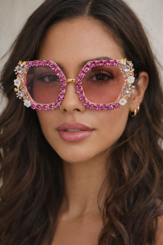 Woman wearing heart-shaped sunglasses with pink lenses and 